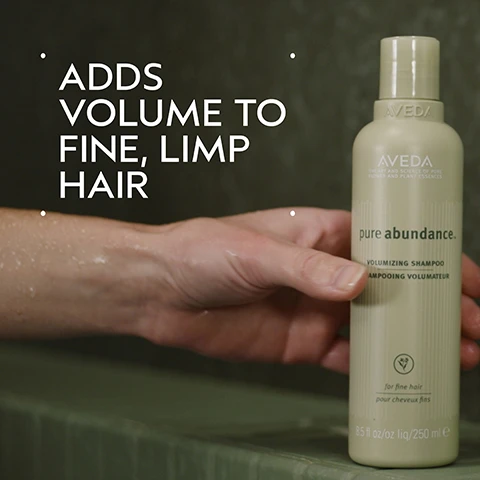Image 2 - A persons hand holds a light green Aveda shampoo bottle against a blurry dark green background, with large white text on the left stating ADDS VOLUME TO FINE, LIMP HAIR, and the bottle displays text including AVEDA THE ART AND SCIENCE OF PURE FLOWER AND PLANT ESSENCES pure abundance. VOLUMIZING SHAMPOO AMPOOING VOLUMATEUR a leaf logo for fine hair pour cheveux fins 8.5 fl oz/oz liq / 250 ml e. Image 3 - A dark green image features a central circular abstract design of swirling blues and greens, with white text reading Acacia Gum & Kaolin Clay and below that, Helps Fill Out Fine Hair. Image 4 - A before and after image shows a woman with short brown hair, on the left her hair is flat and parted in the middle, and on the right it is voluminous and styled with a side part; the visible text reads BEFORE Unwashed Hair AFTER Results with Pure Abundance™ Volumizing Shampoo, Volumizing Clay Conditioner, Style-Prep™, and Volumizing Hair Spray, Phomollient™ Styling Foam. Blow dried with Mini Wooden Paddle Brush. Image 5 - The image displays a four-step hair care guide on a dark green background with the title HOW TO USE, showing a person washing hair for 01 CLEANSE Pure Abundance™ Volumizing Shampoo, dispensing conditioner for 02 CONDITION Pure Abundance™ Volumizing Conditioner, brushing product into hair for 03 STYLE Pure Abundance™ Style-Prep™ Phomollient™ Styling Foam & Mini Paddle Brush, and spraying hair for 04 HOLD Pure Abundance™ Volumizing Hair Spray. Image 6 - A split image shows a womans reddish-brown bob cut hair from behind, with the left side showing unwashed, flatter hair labeled BEFORE Unwashed Hair, and the right side showing more voluminous, styled hair labeled AFTER Results with Pure Abundance™ Volumizing Shampoo, Volumizing Clay Conditioner, Style-Prep™, and Volumizing Hair Spray, Phomollient™ Styling Foam. Blow dried with Mini Wooden Paddle Brush. Image 7 - A frothy, off-white blob of liquid with many small and large bubbles, spread on a white background. Image 8 - The image shows three white certification logos on a dark green leafy background, reading 100% VEGAN, Certified B Corporation, and Cruelty Free INTERNATIONAL.