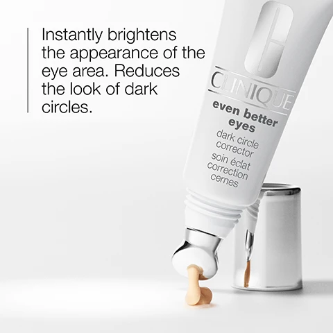 Image 1 - A tube of Clinique Even Better Eyes Dark Circle Corrector is shown dispensing a small amount of cream with the text, Instantly brightens the appearance of the eye area. Reduces the look of dark circles.
Image 2 - A woman with long dark hair is applying a skincare product under her left eye using a silver roller applicator; the product appears to be a light cream or gel.
Image 3 - A close-up of a shimmery, golden surface featuring icons for refresh and brighten with the text refresh and brighten.
Image 4 - Image shows two clear glass containers next to a light green vertically striped background with text indicating the product is free of fragrance, sodium lauryl sulfate, and sodium laureth sulfate.