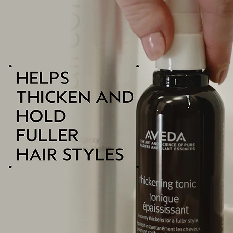 Image 2 - A hand holds a dark brown Aveda thickening tonic bottle with a white pump top, and text on the left says HELPS THICKEN AND HOLD FULLER HAIR STYLES, while the bottle itself reads AVEDA THE ART AND SCIENCE OF PURE FLOWER AND PLANT ESSENCES thickening tonic tonique épaississant instantly thickens for a fuller style épaissit instantanément les cheveux pour une coiffure plus dense. Image 3 - A split image shows a woman with long red hair in a before and after comparison, with her wavy and slightly frizzy hair on the left side, labeled BEFORE and Unwashed Hair, contrasting with her smooth, straight, and styled hair on the right side, labeled AFTER and Results with Cherry Almond Softening Shampoo and Conditioner, Speed of Light Blow Dry Accelerator, Thickening Tonic, Botanical Repair™ Bond-Building Styling Crème, and Air Control Light Hold Hair Spray. Blow dried with Wooden Paddle Brush. Image 4 - A dark green image features a white circle containing green wheat, an amla fruit with green leaves, and multicolored corn kernels, with the text AMLA, WHEAT, & CORN HELP THICKEN AND HOLD YOUR FULLER HAIRSTYLE. Image 5 - The image displays a four-step hair care routine with circular photos: first, hands washing lathered hair; second, a hand squeezing conditioner into a palm; third, a hand spraying a hair product; and fourth, a collection of hair styling products and a paddle brush on a tray. The visible text reads: HOW TO USE 01 CLEANSE Cherry Almond Softening Shampoo 02 CONDITION Cherry Almond Conditioner 03 PREP Speed of Light Blow Dry Accelerator 04 STYLE Thickening Tonic, Botanical Repair™ Bond-Building Styling Crème, Air Control Light Hold Hair Spray & Wooden Paddle Brush. Image 6 - A single, translucent, pale yellow-beige drop of viscous liquid with small bubbles is shown on a white background. Image 7 - Against a background of dark green leaves and a red plant, three white logos are shown: a circular logo with a large V and 100% VEGAN text, a Certified B Corporation logo with a B in a circle, and a Cruelty Free INTERNATIONAL logo featuring a leaping rabbit.