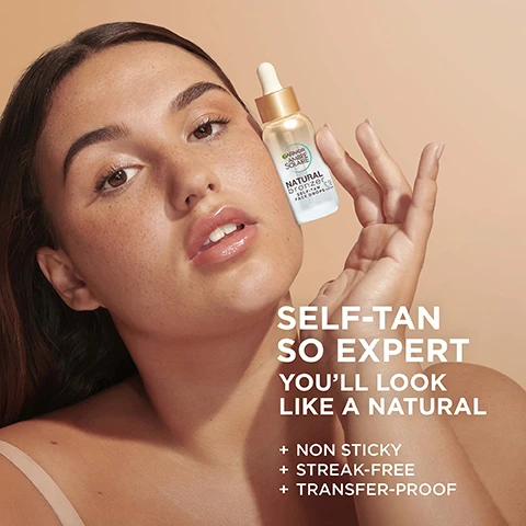 Image 1 - A woman holds a bottle of Garnier Ambre Solaire Natural Bronzer Self-Tan Face Drops near her face with the text SELF-TAN SO EXPERT YOULL LOOK LIKE A NATURAL + NON STICKY + STREAK-FREE + TRANSFER-PROOF visible. Image 2 - Three close-up images of a womans face showing different levels of tan from pale to medium, with text reading 0 DROP, 4 DROPS, 12 DROPS, GRADUAL & NATURAL LOOKING TAN. Image 3 - A close-up abstract image of liquid, bubbles, and a coconut shell edge with the text SKINCARE INFUSED and HYALURONIC ACID + COCONUT WATER. Image 4 - A dropper bottle with liquid and spilled liquid next to instructions for use. The text says HOW TO USE FACE DROPS STEP 1. MIX ADD 4-12 DROPS TO YOUR MOISTURISER FOR TAILOR-MADE GLOW STEP 2. APPLY SMOOTH OVER YOUR FACE AND NECK STEP 3. BLEND USE A REUSABLE PAD TO BLEND INTO THE HAIRLINE & EYEBROWS STEP 4. REPEAT REAPPLY AS NEEDED FOR EXTRA HYDRATION & BRONZING. Image 5 - Close-up of a light-colored liquid or gel with bubbles and text labels CLEAR TRANSPARENT FORMULA, FRAGRANCE FREE, TESTED UNDER DERMATOLOGICAL CONTROL, SUITABLE FOR SENSITIVE SKIN. Image 6 - Close-up of a womans face with radiant skin and glossy lips, with text overlay that says GLOWY & RADIANT RESULTS + HYDRATED SKIN + HEALTHY GLOW. Image 7 - A flat lay shows four Garnier Ambre Solaire Natural Bronzer tanning products including face drops, a body mist, a self-tan mousse, and a self-tan lotion, with overlay text reading Gradual Natural Face Tan Drops With Hyaluronic Acid, Easy Quick-Drying Tan Mist With Vitamin E, 1-Week Tan With Weightless Quick-Dry Mousse, Hydrating Tan Lotion, and Natural Bronzer. Image 8 - A bottle of Garnier Ambre Solaire Natural Bronzer Self-Tan Face Drops is shown on a light brown background with green borders, featuring the text Cruelty Free International, Vegan Formula, Garnier Ambre Solaire, Natural bronzer, Self-tan face drops, and *No animal-derived ingredients or by-products.