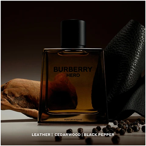 Image 1 - A dark, moody image of a Burberry Hero perfume bottle, featuring a rectangular design with a black cap, surrounded by leather, wood, and black peppercorns, with visible text reading Burberry HERO PARFUM INTENSE and Leather | Cedarwood | Black Pepper.
Image 2 - Image shows various Burberry fragrance bottles labeled Eau de Toilette, Eau de Parfum, Parfum, and Parfum Intense, with descriptions of their scents and intensity levels displayed below each bottle, along with images of natural elements like wood and leaves; visible text includes Burberry HERO and information about scent notes and intensity.
Image 3 - A brown glass perfume bottle labeled Burberry Hero 100ml is on the left, next to a refillable brown container labeled Burberry Hero Refill 200ml on the right, both set against a dark background.
Image 4 - An instructional image showing three steps to refill Burberry Hero bottles: step 1 is unscrewing the pump, step 2 is screwing the refill onto the bottle cap, and step 3 indicates that the bottle will refill automatically, with a note that refills are available on 100ml bottles only.
Image 5 - A shirtless man with tousled hair is sitting on a horse by the water, with a perfume bottle in the foreground displaying the text Burberry Hero and The New Parfum Intense.
